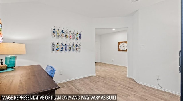 unfurnished office featuring lofted ceiling, wood finished floors, and baseboards