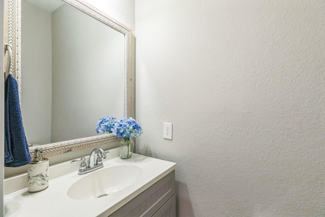 bathroom featuring a textured wall and vanity