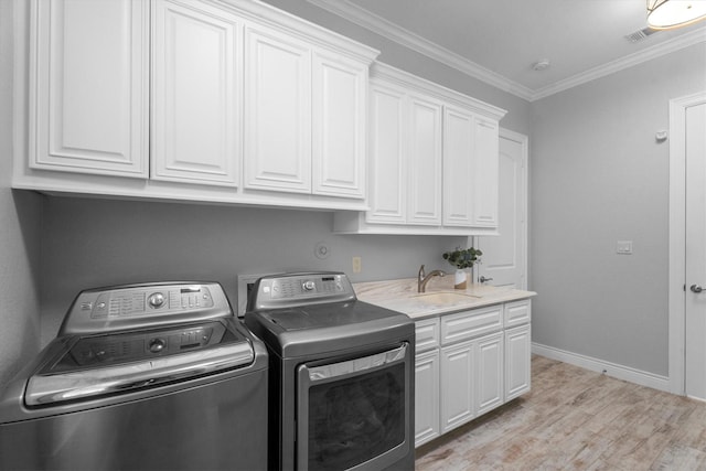 13130 Victoria Trce, Montgomery, TX 77316 - washroom with crown molding, a sink, light wood-type flooring, cabinet space, and washing machine and dryer
