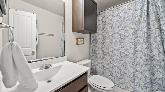 bathroom with toilet, a shower with shower curtain, vanity, and a textured ceiling