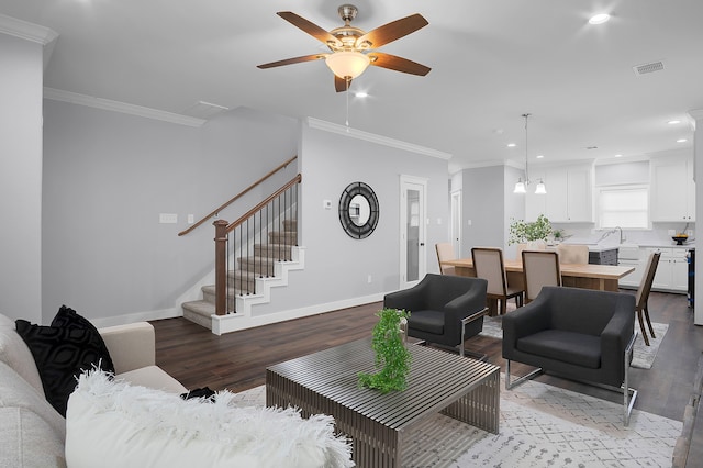 living area featuring visible vents, baseboards, wood finished floors, and stairway