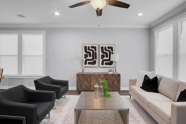 living area with ceiling fan, visible vents, crown molding, wood finished floors, and baseboards