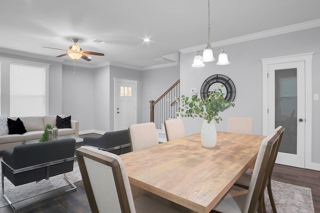 dining area with ceiling fan, stairs, dark wood-type flooring, visible vents, and ornamental molding
