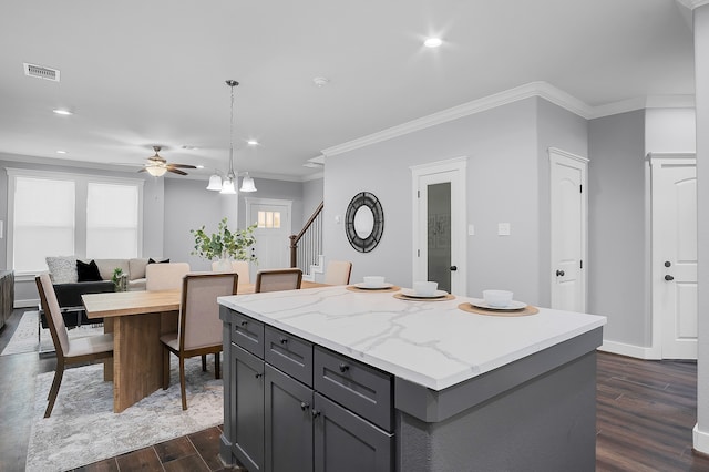 kitchen featuring visible vents, dark wood-style flooring, ceiling fan, a center island, and gray cabinets