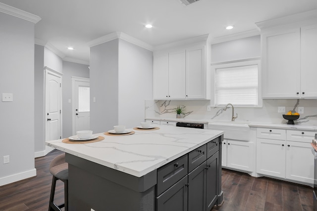 kitchen featuring crown molding, dark wood finished floors, a kitchen island, and white cabinets