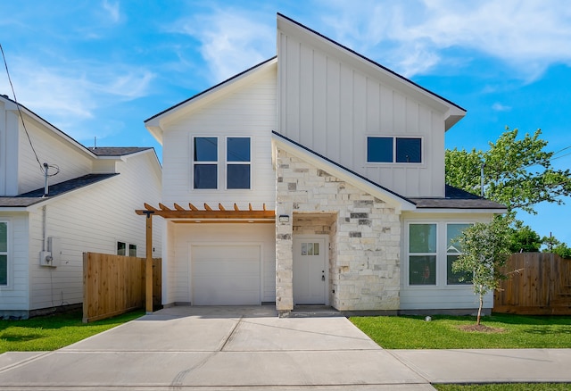 view of front of house featuring board and batten siding, fence, concrete driveway, and a garage