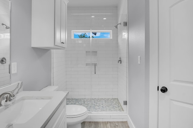 full bath with toilet, a shower stall, wood finished floors, and vanity