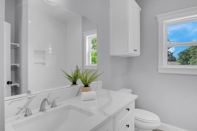 bathroom with toilet, baseboards, and vanity