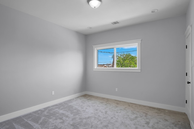 spare room featuring carpet flooring, baseboards, and visible vents