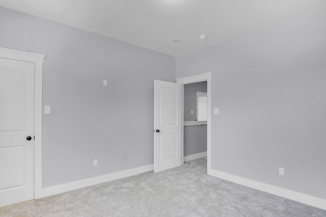 carpeted empty room with baseboards