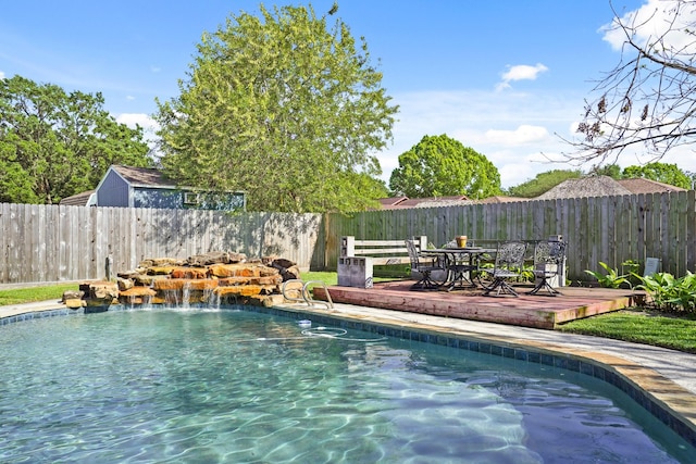 view of pool with a fenced backyard, a wooden deck, and a fenced in pool