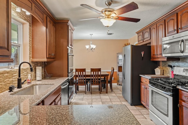 kitchen with a sink, backsplash, visible vents, and stainless steel appliances