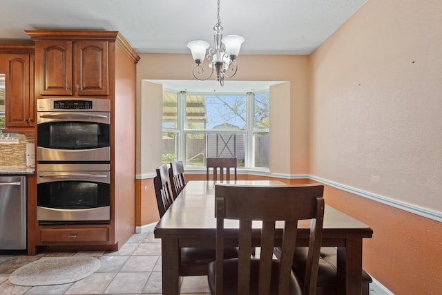 dining room with a notable chandelier and baseboards