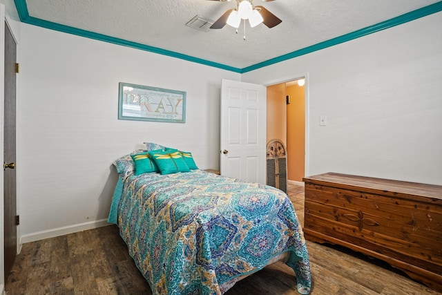 bedroom with ceiling fan, a textured ceiling, visible vents, wood finished floors, and baseboards