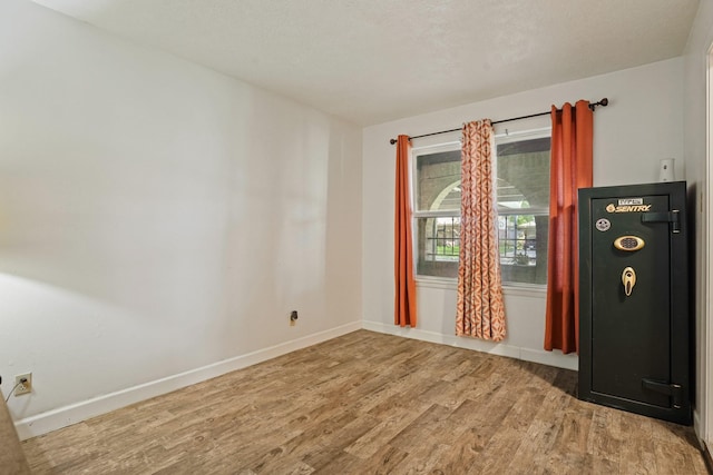 unfurnished room with baseboards and wood finished floors