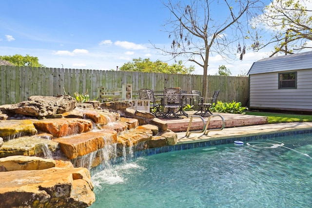 view of pool featuring an outbuilding, a fenced backyard, a fenced in pool, and a shed