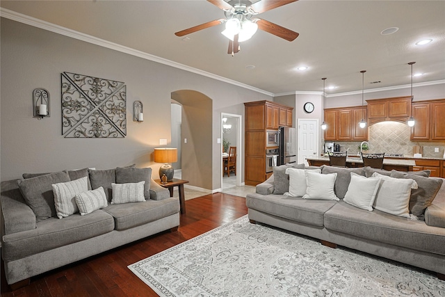 12203 Pinelands Park Ln, Humble, TX 77346 - living room with ceiling fan, arched walkways, ornamental molding, dark wood-style floors, and baseboards