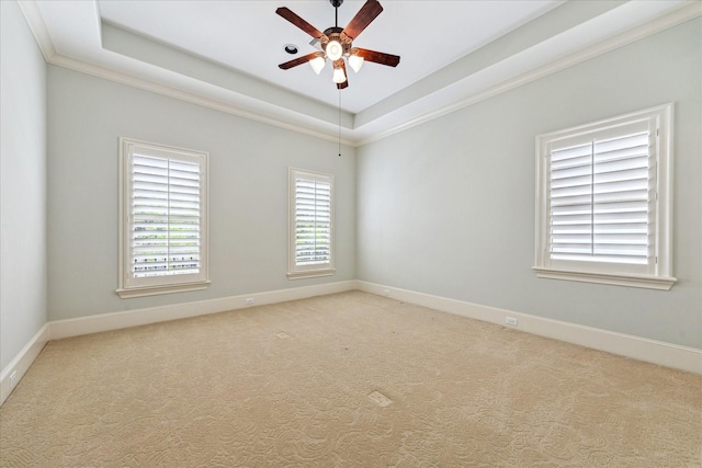 unfurnished room with a tray ceiling, ceiling fan, light colored carpet, and baseboards