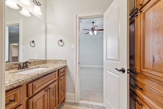 bathroom with ceiling fan, vanity, and baseboards