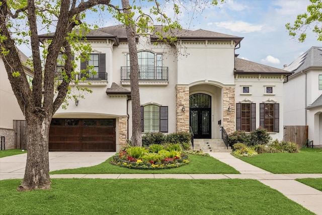 view of front of house with stucco siding, driveway, stone siding, and a garage