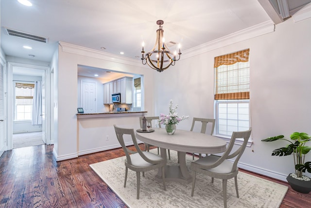 5976 Kansas St, Houston, TX 77007 - dining space with dark wood-style floors, a chandelier, ornamental molding, and baseboards