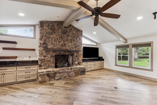 5807 Lilac St, Katy, TX 77493 - living room featuring baseboards, lofted ceiling with beams, a stone fireplace, ceiling fan, and light wood-style flooring