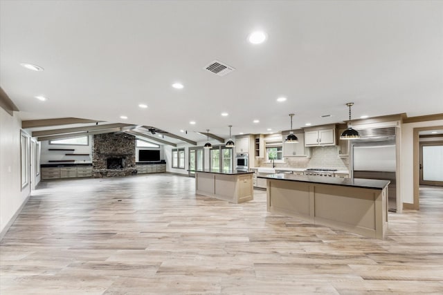 5807 Lilac St, Katy, TX 77493 - kitchen featuring lofted ceiling with beams, visible vents, a kitchen island, appliances with stainless steel finishes, and open floor plan