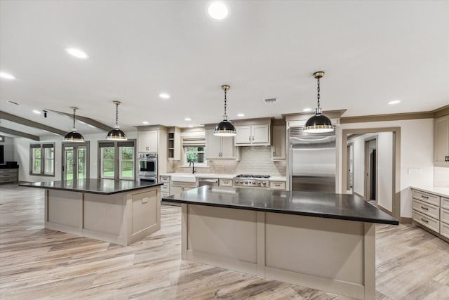 5807 Lilac St, Katy, TX 77493 - kitchen featuring light wood-style flooring, visible vents, appliances with stainless steel finishes, backsplash, and a spacious island