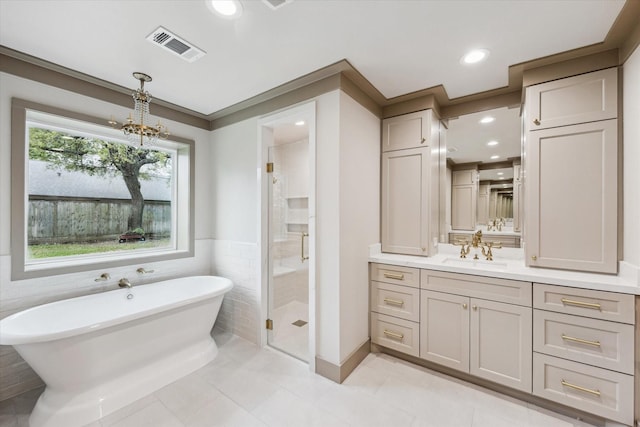 5807 Lilac St, Katy, TX 77493 - bathroom featuring a soaking tub, an inviting chandelier, a shower stall, vanity, and visible vents