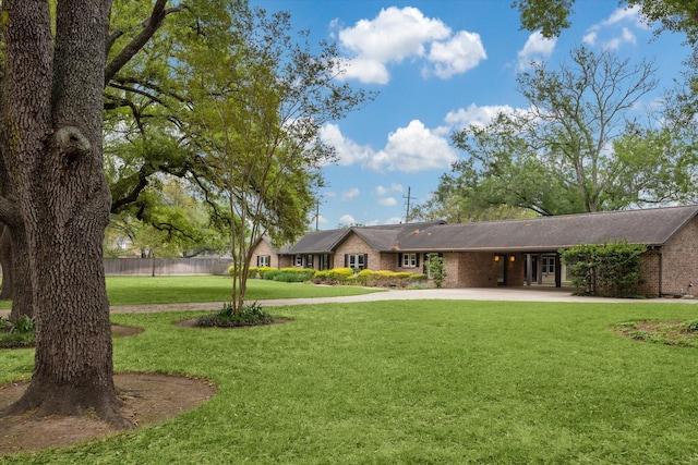 5807 Lilac St, Katy, TX 77493 - view of front of home featuring a carport, fence, concrete driveway, brick siding, and a front lawn