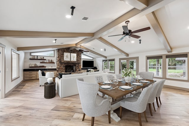 5807 Lilac St, Katy, TX 77493 - dining space featuring a stone fireplace, ceiling fan, vaulted ceiling with beams, and a wealth of natural light