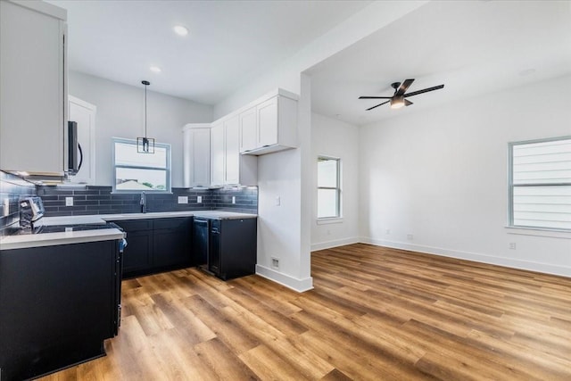 kitchen featuring backsplash, light countertops, a ceiling fan, and stove