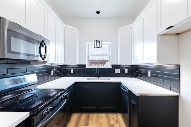 kitchen featuring light countertops, a sink, backsplash, and stainless steel appliances