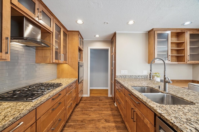kitchen with brown cabinetry, stainless steel appliances, and a sink
