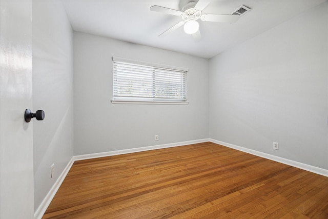 unfurnished room featuring wood finished floors, visible vents, baseboards, and ceiling fan