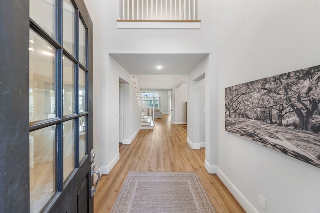 10593 Lake Palmetto Dr, Conroe, TX 77385 - hall featuring light wood-type flooring, baseboards, and stairs