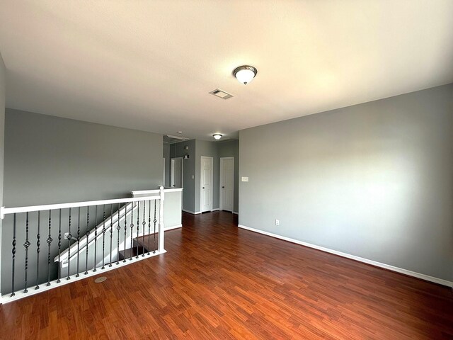 spare room with visible vents, baseboards, and wood finished floors