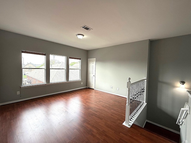 spare room with visible vents, baseboards, and wood finished floors
