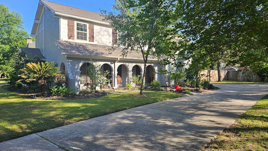 614 Brook Hollow Dr, Conroe, TX 77385 - view of front of house featuring a front yard, a porch, fence, and concrete driveway