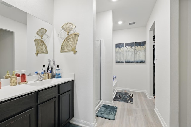 11034 Hillside Creek Dr, Humble, TX 77396 - bathroom with visible vents, baseboards, vanity, and wood finished floors