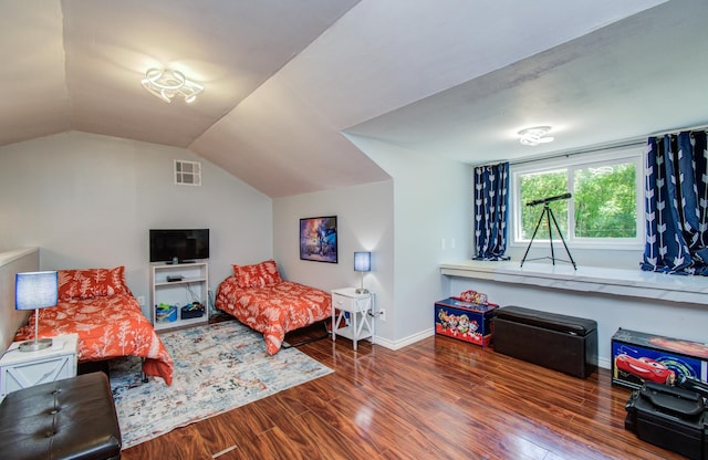 bedroom featuring baseboards, visible vents, wood finished floors, and vaulted ceiling