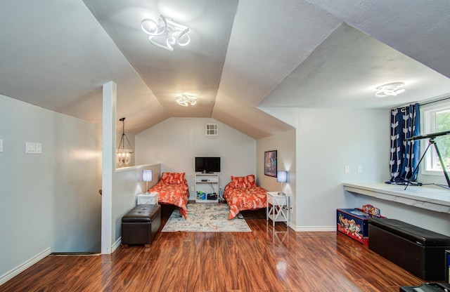 bedroom with baseboards, visible vents, wood finished floors, and lofted ceiling