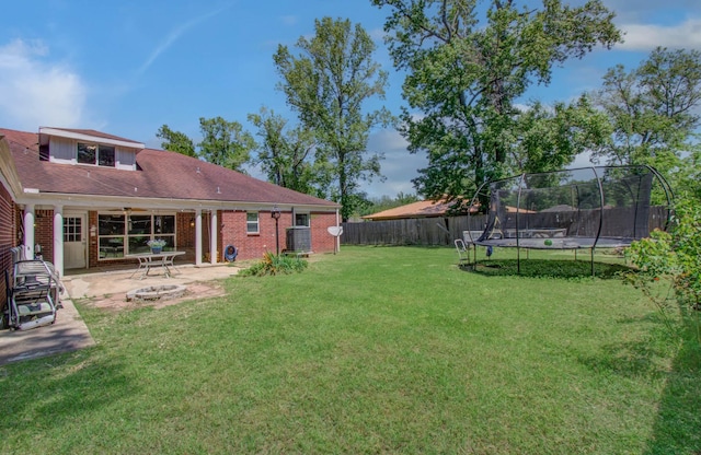 view of yard with a patio, a fenced backyard, and a trampoline