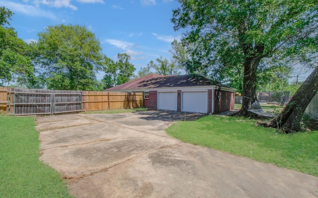 view of home's exterior featuring driveway, a lawn, a garage, brick siding, and fence