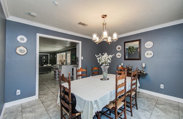 dining space featuring an inviting chandelier, baseboards, ornamental molding, and visible vents