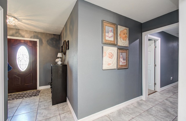 entryway featuring baseboards and light tile patterned flooring