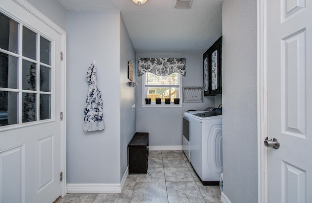 laundry room with separate washer and dryer, baseboards, cabinet space, and visible vents