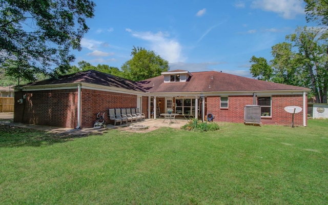 rear view of property with a lawn, a patio area, and brick siding