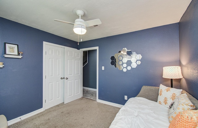 bedroom with baseboards, ceiling fan, carpet, and a closet