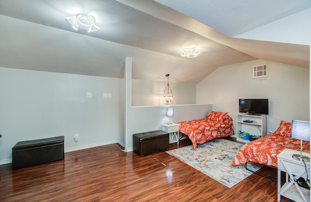 bedroom featuring baseboards, lofted ceiling, wood finished floors, and visible vents